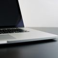 silver laptop computer on black table