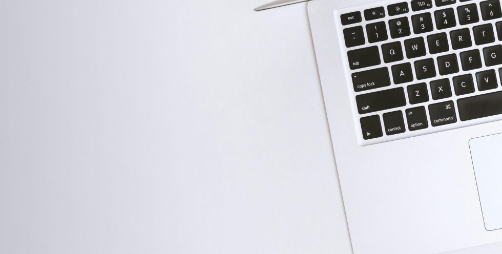 Free Aerial view of a sleek laptop keyboard on a clean, white surface, ideal for tech backgrounds. Stock Photo