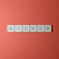 Free Close-up of keyboard keys spelling 'BACKUP' placed on a coral-colored surface. Stock Photo