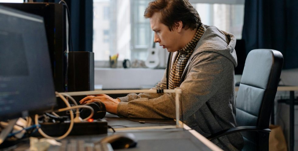 Free A concentrated professional working at a computer in a modern office setting. Stock Photo